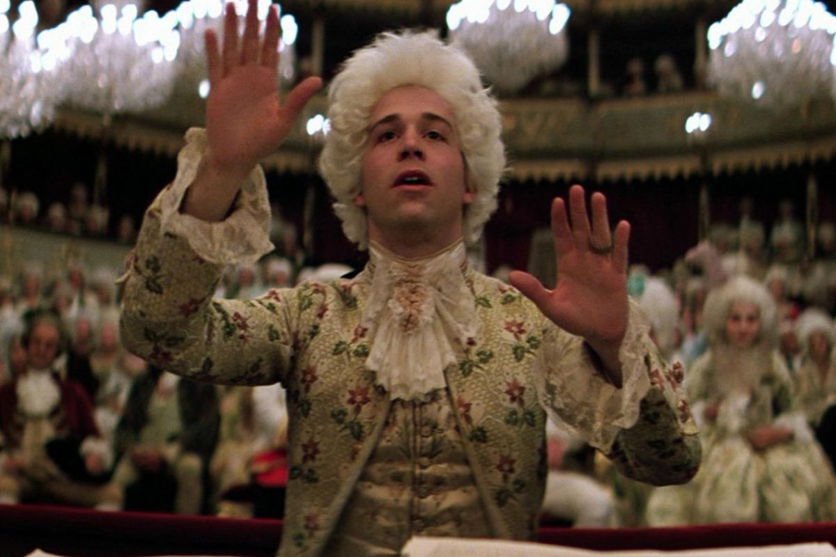 Wolfgang Amadeus Mozart with hands outstretched, conducting a symphony in Amadeus